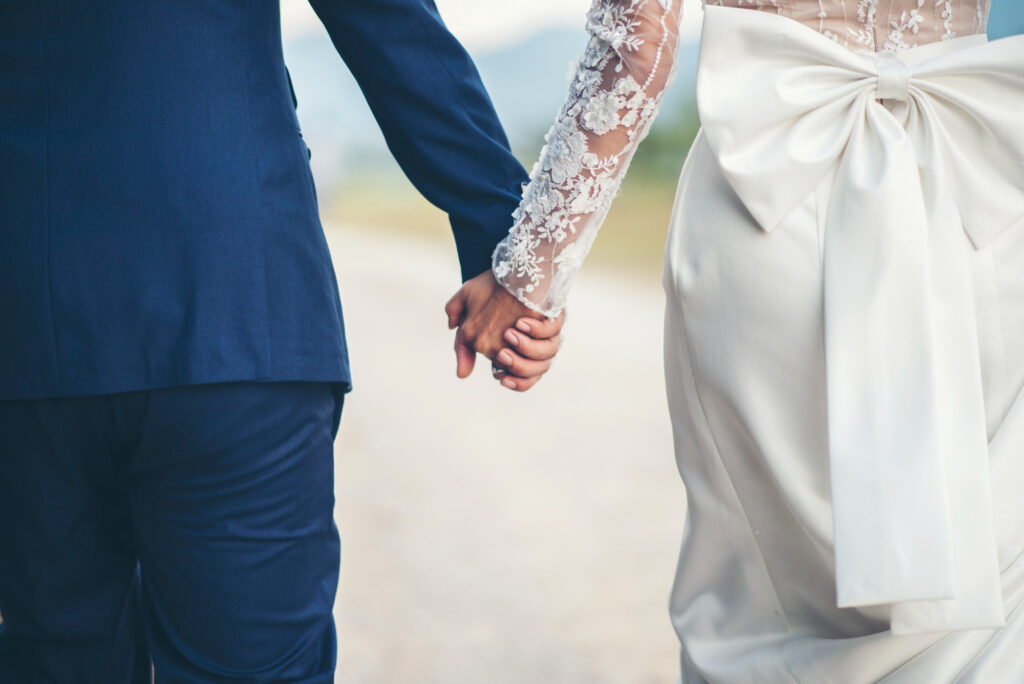 close-up-of-married-couple-holding-hands-in-wedding-day